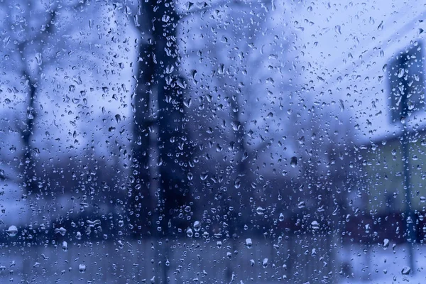 Obrázek dešťových kapek na pozadí skleněného okna. Modrý tón — Stock fotografie