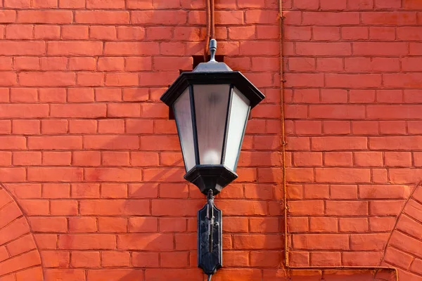 Forged lantern on a red brick wall with  space for lettering or — Stock Photo, Image