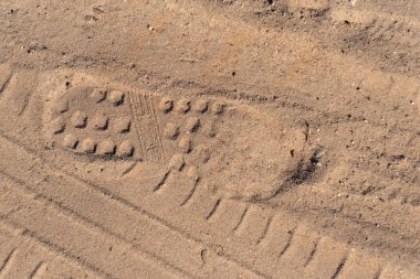 Kum üzerinde parça ayakkabı ve araba tekerlekleri