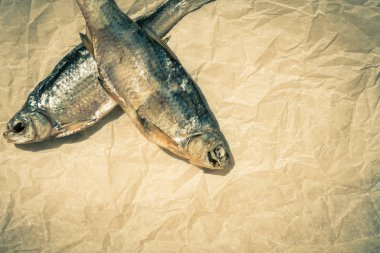 Parşömen kağıdında iki kurutulmuş balık. Seçici odak. Kopyalama alanı.