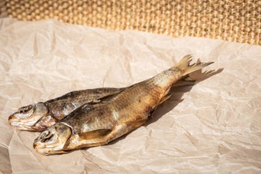 Parşömen kağıdında iki kurutulmuş balık. Seçici odak. Kopyalama alanı.
