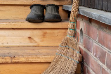 Evin eşiğindeki eski süpürge. Yakından kapatın. Yumuşak odaklama.