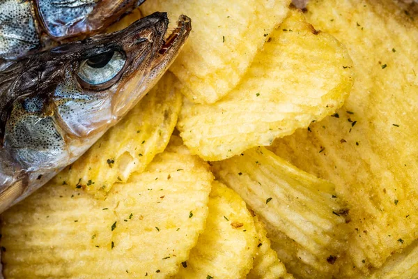 Fish and chips. Dried fish and fluted chips, a beer snack. Top view. Selective focus.