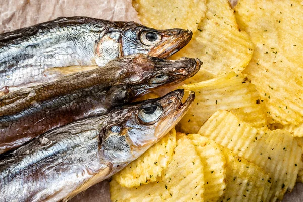 Fish and chips. Dried fish and fluted chips, a beer snack. Top view. Selective focus.