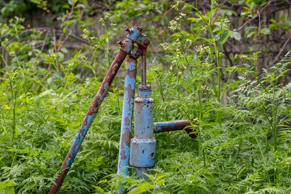 Rus köyünde Vintage paslı su çeşme el pompası. Terk edilmiş su kuyu başı.