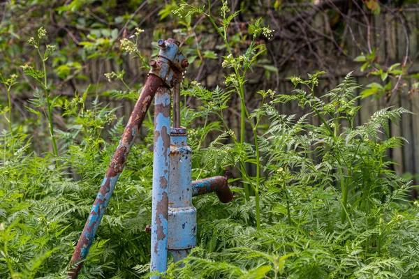 Rus köyünde Vintage paslı su çeşme el pompası. Terk edilmiş su kuyu başı.