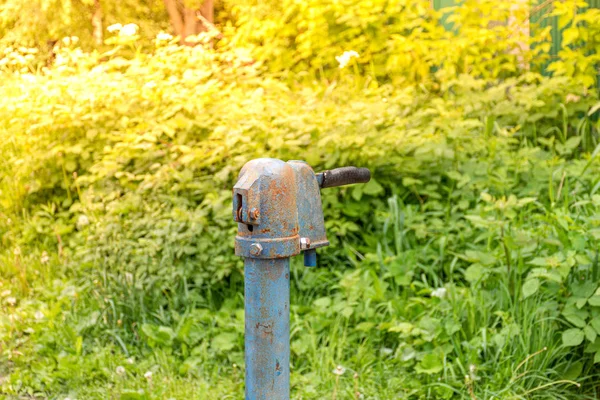 Rus köyünde Vintage paslı su çeşme el pompası. Terk edilmiş su kuyu başı.