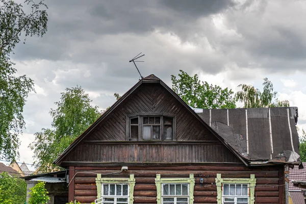Casa velha em uma aldeia russa contra um céu nublado, nuvens cinzas — Fotografia de Stock