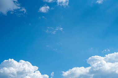 Güneşli bir günde mavi gökyüzünde kalın beyaz bulutlar. Doğal arka plan