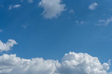 Güneşli bir günde mavi gökyüzünde kalın beyaz bulutlar. Doğal arka plan