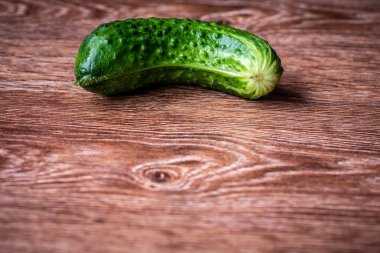 Masada bir taze salatalık yatıyor. Close. Seçici odak. Metin veya tasarım alanı.