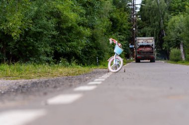 Bir kır yolunun kenarında çocuk bisikleti. Bulanık bir sırtta