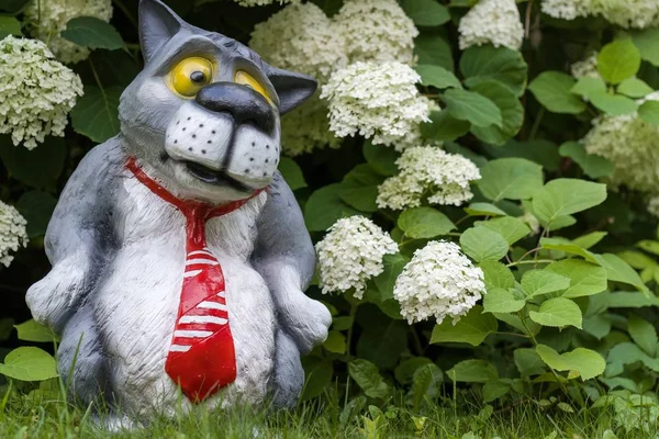 A figura de um lobo de gravata vermelha. Brinquedo decorativo para o jardim — Fotografia de Stock