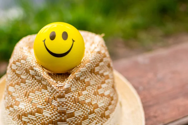 Un fragmento de un sombrero y una bola sonriente cara sonriente en un borroso —  Fotos de Stock