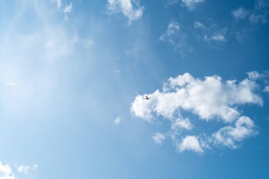 Kabarık bulutlar ile mavi gökyüzü bir arka plan üzerinde Küçük uçak