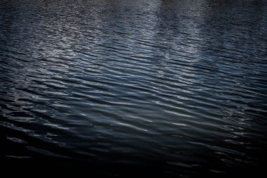 Gece su yüzeyinde ay yansımaları var. Yumuşak odaklanma. Soyut doğal arkaplan