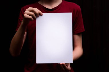 Kağıt çarşaf genç bir insanın elinde. Yakın plan. Harfler ve tasarım için boşluk
