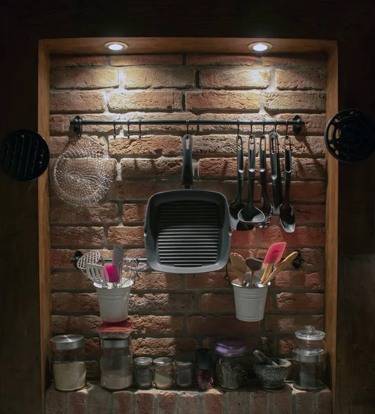 Old brick kitchen wall with wooden frame and kitchen accessories.