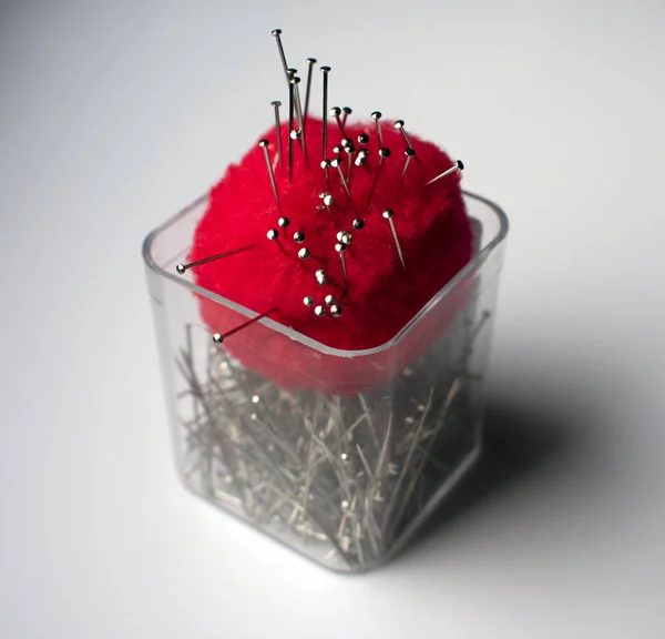 Sewing pins and pincushion in plastic cup