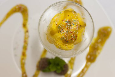 sprinkles ve yaratıcı bir martini cam kaplama şurubu ile sarı dondurma