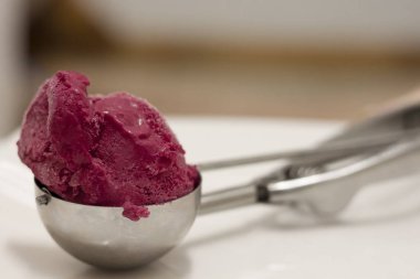 bir dondurma kaşık kaşık parlak mor dondurma topu