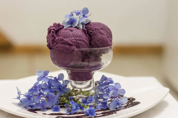 Colheres de sorvete roxo profundo decorado com flores extravagantes Imagem De Stock