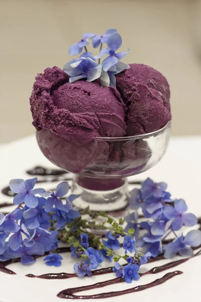 Colheres de sorvete roxo profundo decorado com flores extravagantes vista de 45 graus Imagens Royalty-Free
