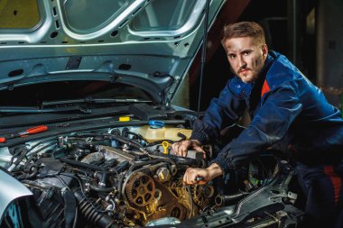 Araba servisi ve bakım yapan tanınmayan tamircinin ellerini kapat. Araba motorunda çalışan tamirci. Otomobil tamiri, servis merkezi. Araba servis merkezinde ingiliz anahtarı çalışan ve araba tamir eden bir tamirci..