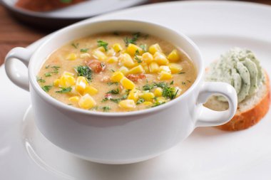 Ahşap arka plan üzerinde beyaz kase mısır çorbası