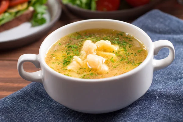 Tavuk çorbası, Patates gnocchi, taze otlar ile. Ahşap arka plan