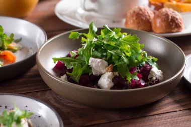 mavi peynir, roka ve ceviz ahşap arka plan üzerinde bir tabak içinde kırmızı pancar salatası