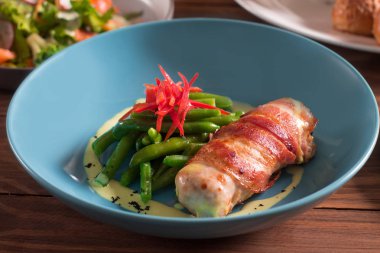 Yeşil fasulye ve kırmızı biber ile kızarmış domuz pastırması, kızarmış tavuk rulo sarılmış