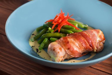 Yeşil fasulye ve kırmızı biber ile kızarmış domuz pastırması, kızarmış tavuk rulo sarılmış