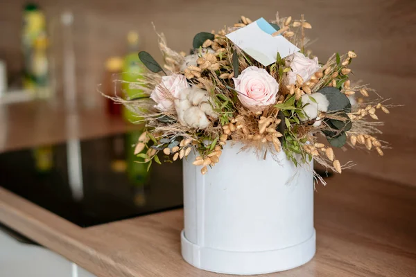 Long lasting flowers decoration. Preserved roses with dried flowers bouquet closeup. Selective focus on home decoration made of decorative plants. Eternal, stabilized, forever rose flower.