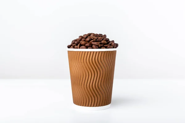Beyaz arka planda kahve fasulyesi dolu zanaat kahve bardağı — Stok fotoğraf