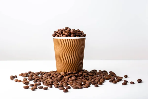 Craft kaffekopp full av kaffe bönor på vit bakgrund — Stockfoto