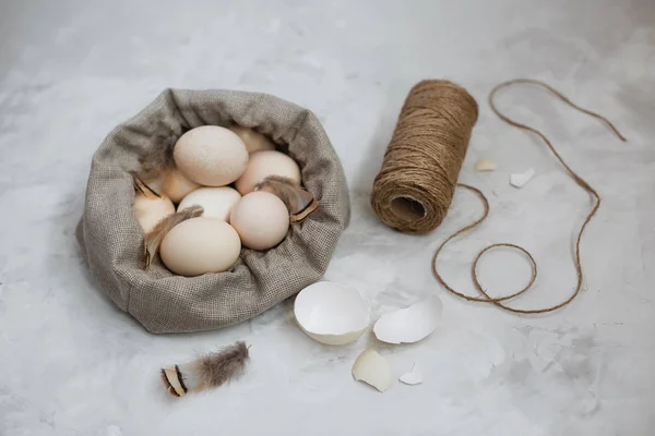 Huevos de Pascua en una bolsa de lona sobre un fondo gris . — Foto de Stock