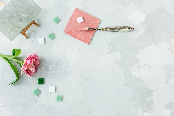 Espacio de trabajo con cuchillo de paleta, pintura de lona, flor de tulipán y — Foto de Stock