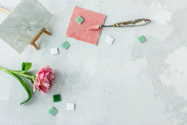 Espacio de trabajo con cuchillo de paleta, pintura de lona, flor de tulipán y — Foto de Stock