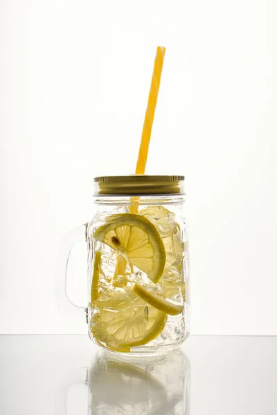 Full glass of fresh cool transparent water with lemon and ice.
