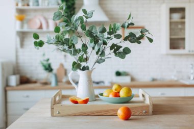 Mutfakta ahşap masa üzerinde duran narenciye ile Plaka