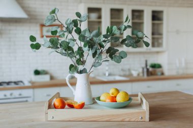 Mutfakta ahşap masa üzerinde duran narenciye ile Plaka