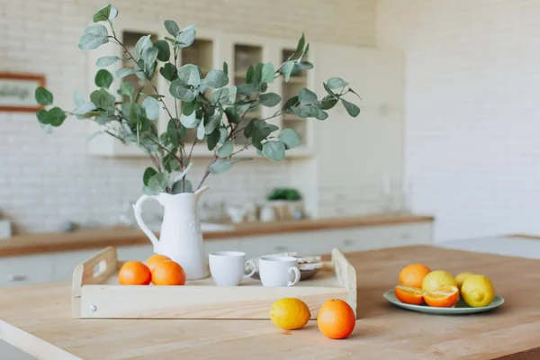 Placa con cítricos de pie sobre mesa de madera en la cocina — Foto de Stock