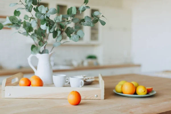 Placa con cítricos de pie sobre mesa de madera en la cocina — Foto de Stock