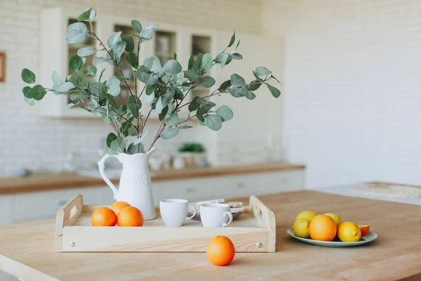 Placa con cítricos de pie sobre mesa de madera en la cocina — Foto de Stock