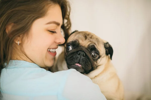 Young woman smiling looking to small pug dog — Stock Photo, Image