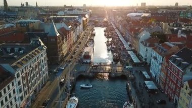 Kopenhag, Danimarka amzing arka ışık gün batımı görüntüleri. Nyhavn yeni Harbour Kanalı ve eğlence bölgesinde köprü. Üstten hava Video görüntüleri görünüm. ileri hareketi. Günbatımı Altın ışık