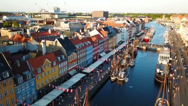 Vídeo del atardecer de Copenhague, Dinamarca. Nyhavn New Harbour canal y distrito de entretenimiento. Vista de vídeo aéreo desde la parte superior. la cámara gira en círculo. Luz dorada del tiempo puesta del sol . — Vídeo de stock
