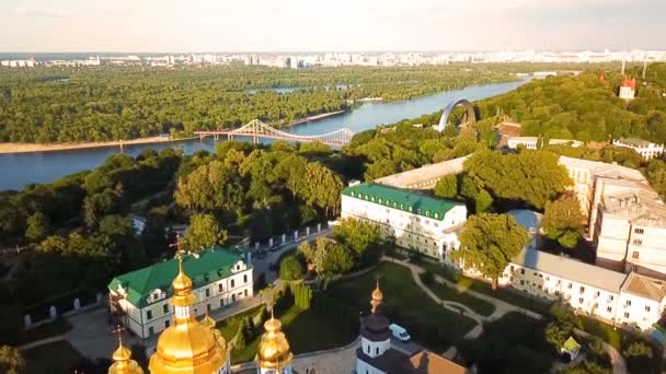 Krásný zlatý Kyjev Ukrajina St. Michaels chrám klášter. Pohled shora. letecké video záběry. Zobrazení na šířku město na Dněpru a Pishokhidnyy Parkovyi most. — Stock video