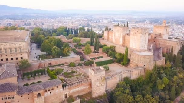 Alhambra. palácio e fortaleza em Granada, Andaluzia, Espanha. Nascer do sol. Imagens de vídeo aéreas do drone. A câmara muda de fortaleza para a cidade. Luz do nascer do sol rosa — Vídeo de Stock